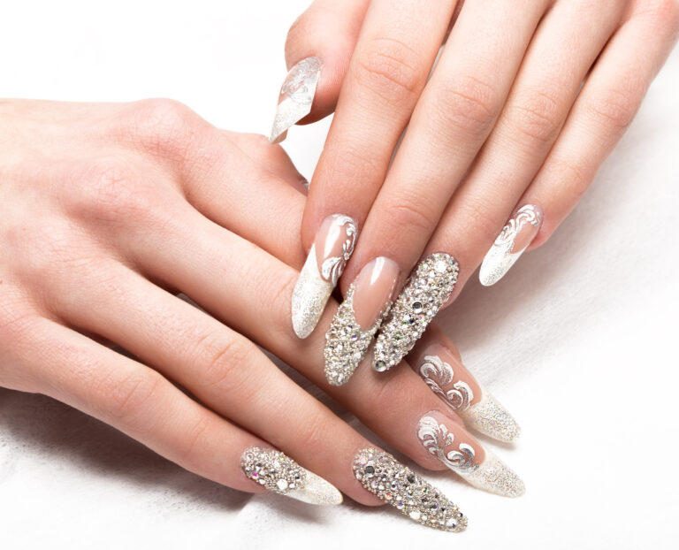 Nail art con strass su manicure da sposa in toni delicati